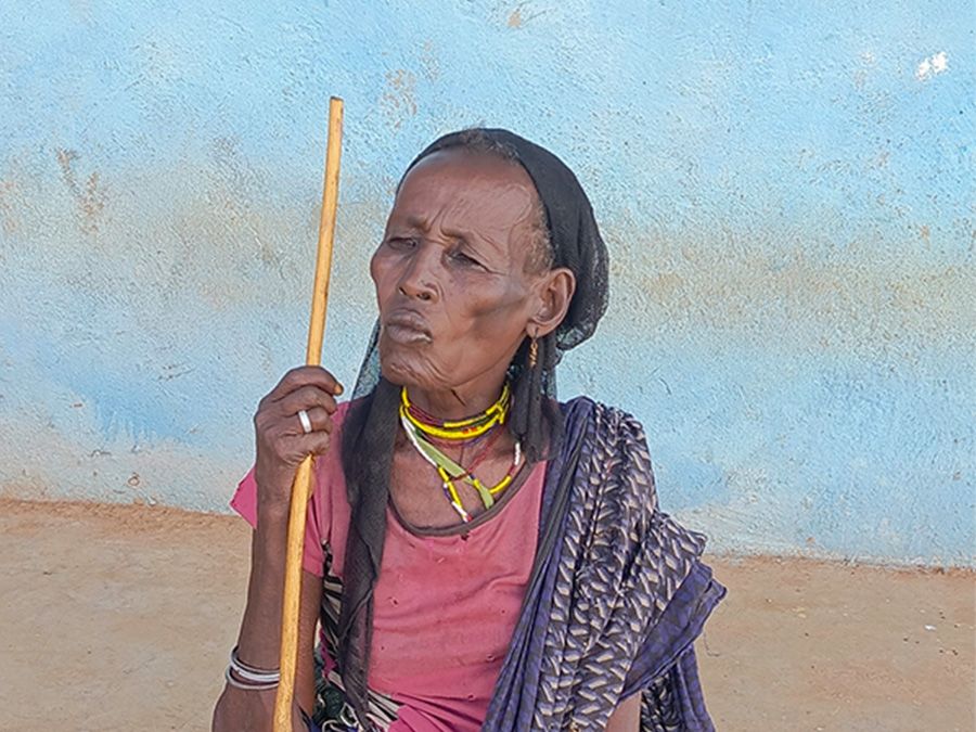 Older person surrounded by 5 children.