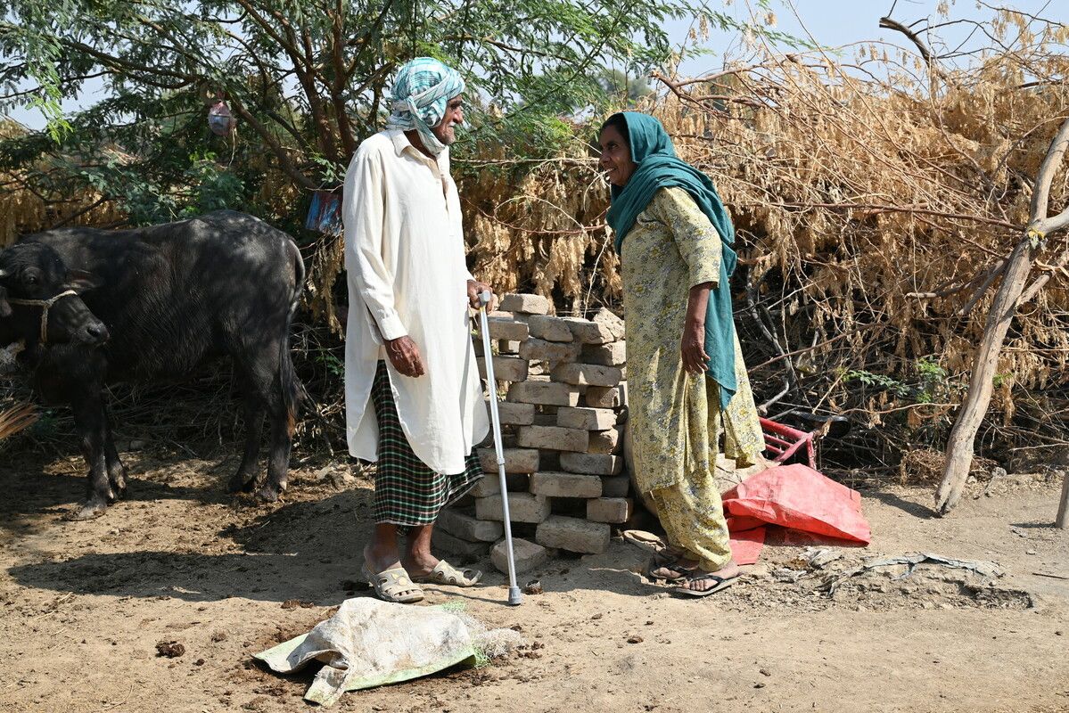 An older couple stood together outside their home