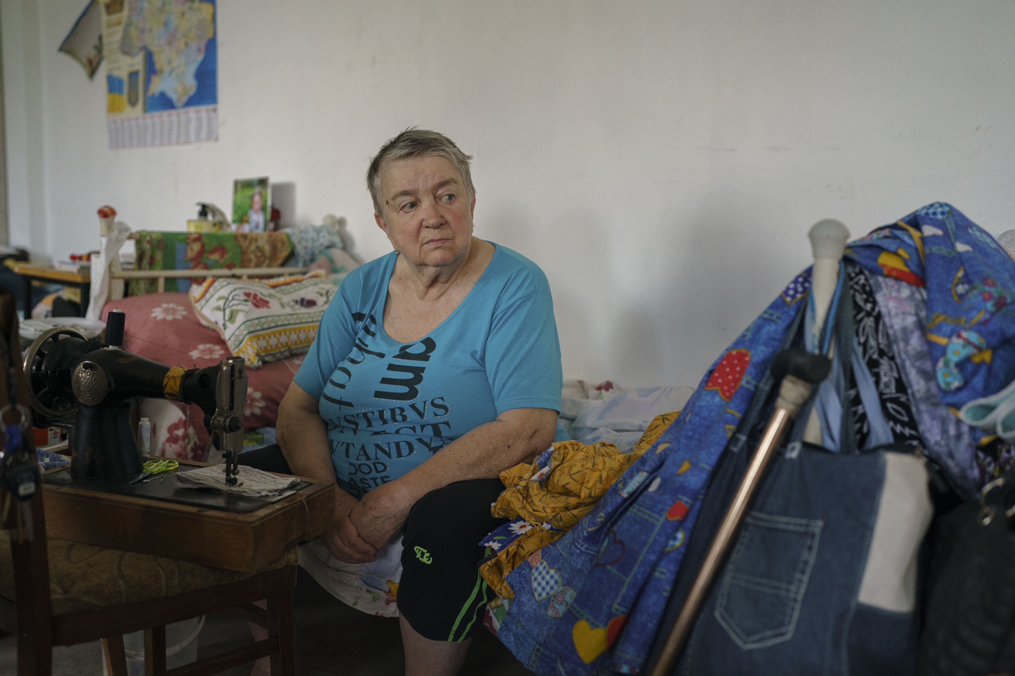 Older Ukranian woman, Lyubov, sits with a pensive expression
